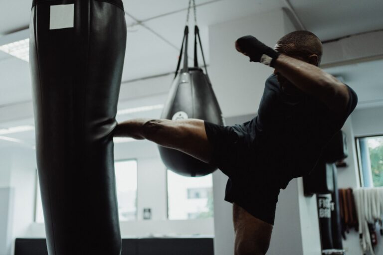 An athlete demonstrating powerful kicks in an indoor gym, focused on fitness and strength.