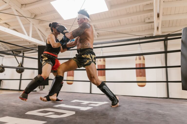 Two athletes sparring in a boxing gym with focus on training and technique.