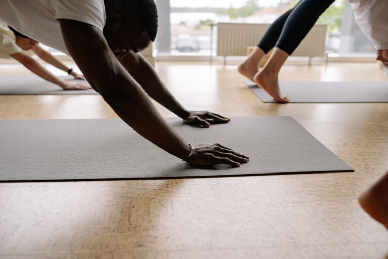 Participants engaging in yoga exercises on mats in a bright studio.