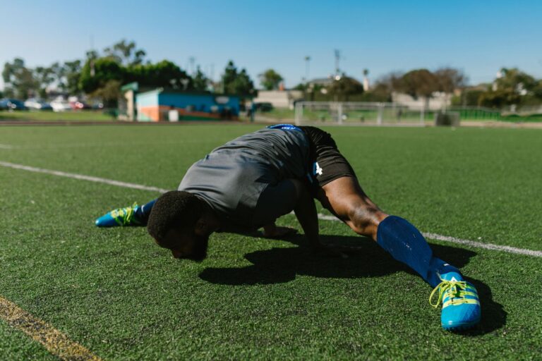 A dedicated athlete doing stretches on a grassy field, showcasing flexibility and strength.