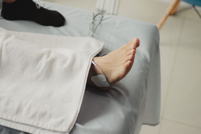A close-up image of a bare foot with a medical electrode, suggesting a healthcare setting.