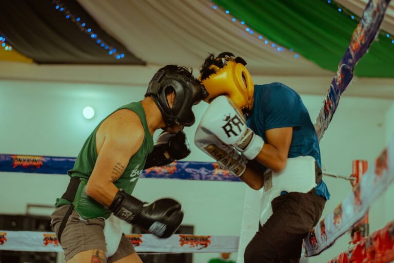 Two boxers engaged in a thrilling match wearing protective headgear and gloves.