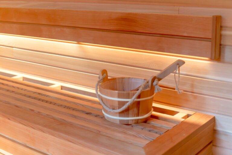 Inviting sauna interior featuring a wooden bucket and ladle, emphasizing relaxation and warmth.