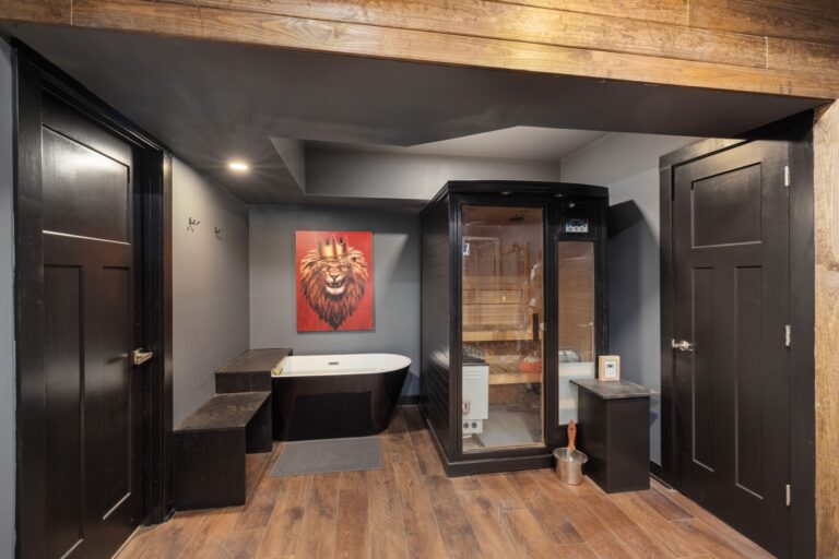 Luxurious home spa featuring a black sauna and bathtub with lion painting.