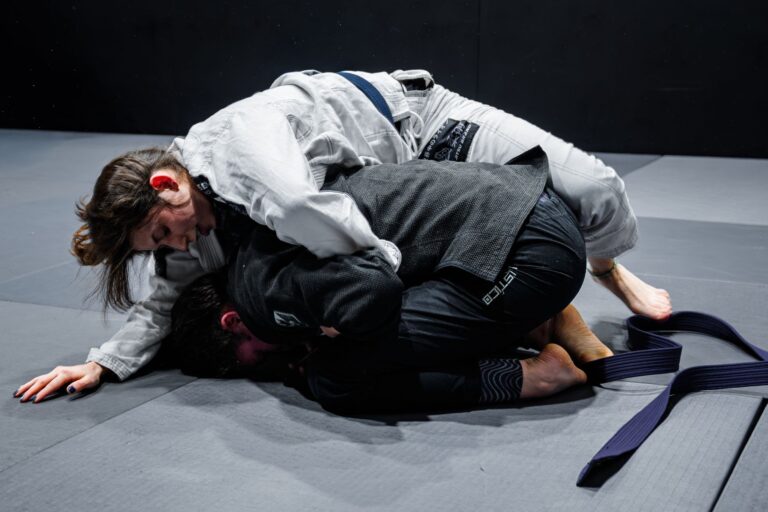 Two athletes engage in a Brazilian Jiu-Jitsu practice match, demonstrating skillful grappling techniques.