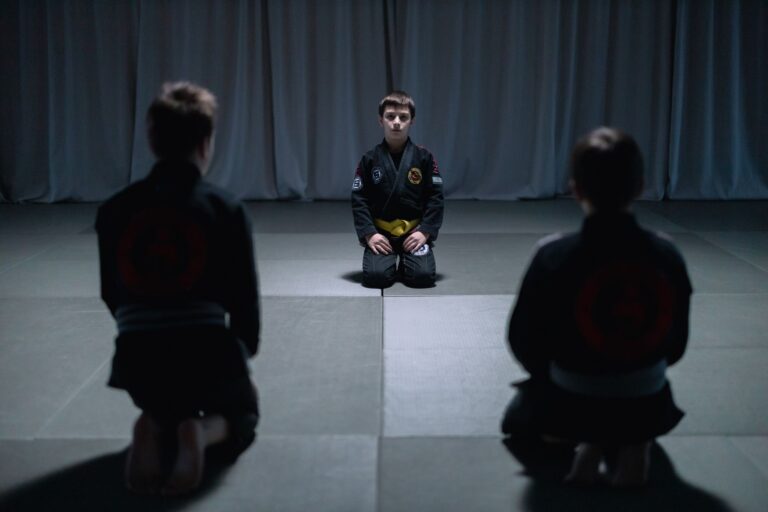 Young boys practicing jiu jitsu indoors, focusing on martial arts training.
