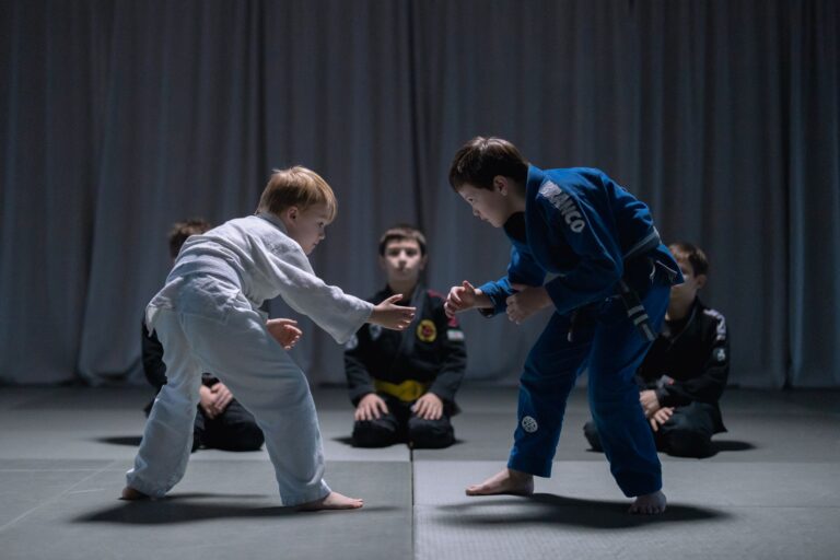 Children engage in martial arts practice, wearing traditional uniforms on a dojo mat.